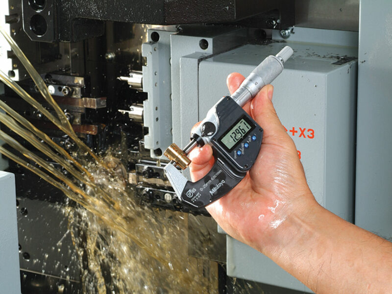 A person showing accurate measurements with a coolant proof mitutoyo micrometer.